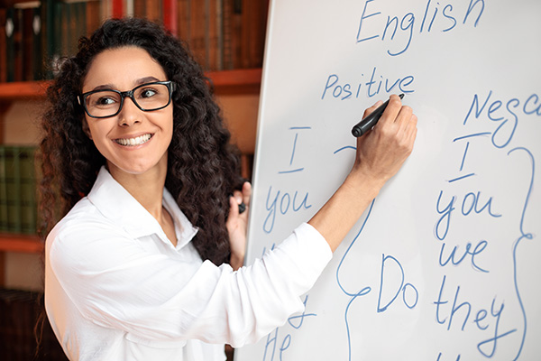 photo of a woman standing in front of a whiteboard with english writing on it