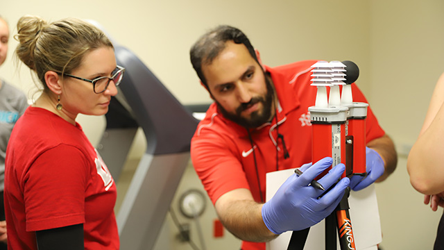 photo of male and female exercise science students interacting with equipment